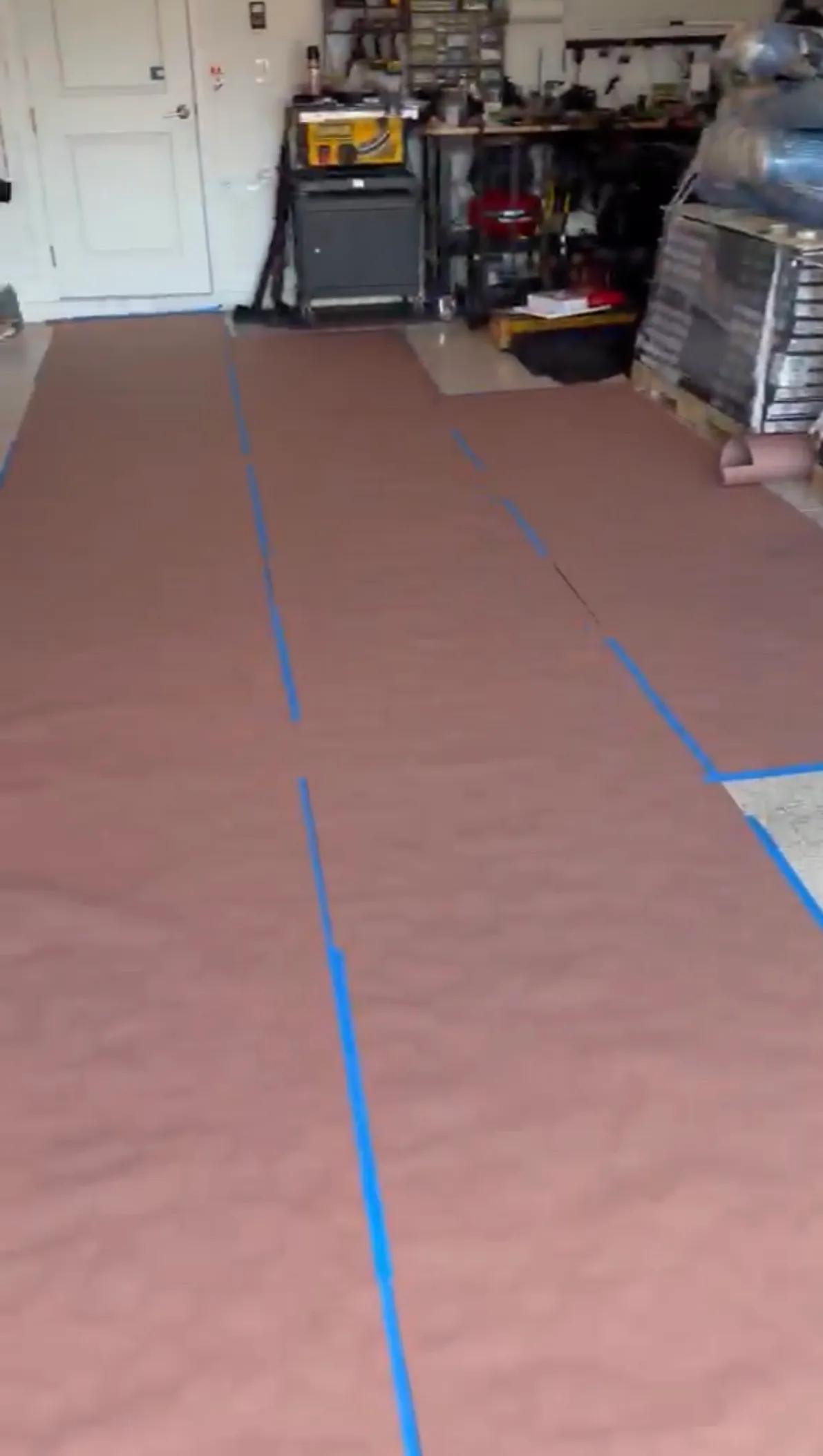 Garage floor protected during LVP flooring installation in Esplanade at Wiregrass Ranch, Wesley Chapel, FL